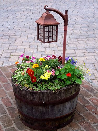 Barrel planter with lamp post.