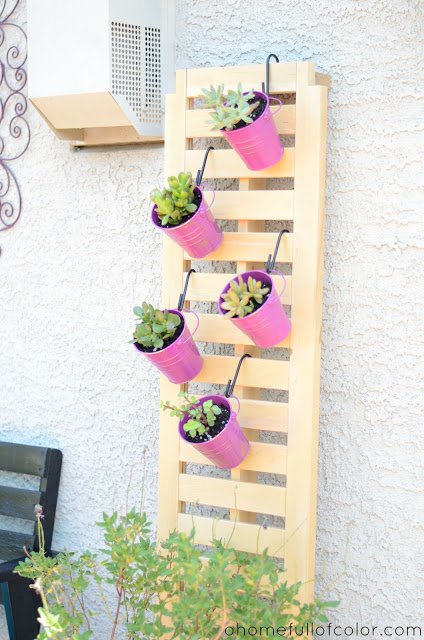 Metal bucket planters on the wall.