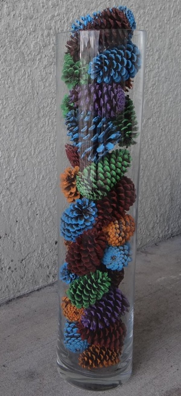 Christmas centerpiece by colorful pinecones in glass jar.